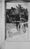 Skyltfönster med en Husqvarna cykel samt reservdelar. E. & K. Karlssons järnhandel på Kungsbackavägen 6.