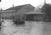 Översvämning vid Fabriksförsäljningen (f. Spårvägshallarna) och Pressbyråns kiosk vid Göteborgsvägen, 1951.
Byggnaderna låg i hörnet mellan Kvarnbygatan och Göteborgsvägen.