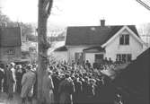 Lösöresauktion i Kållered 1940-tal. Flera män står samlade framför ett hus.