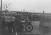 På bilden sitter Vitalis Örtlund på sin motorcykel, en VSO 250, vid Texacomacken, som låg vid Brandahls fabriker nära spårvägens vändslinga. Bilden är tagen då han gjorde rekryten. Året är 1934 eller 1935.
