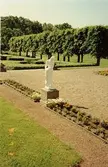 En staty står mellan blomsterrabatterna utanför Gunnebo slott, juli 1991.