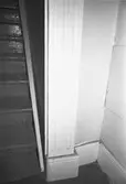 Kvarnfallet 31, röda huset, G-3, hösten 1994. Interiör från Röda husets undervåning. Bilden visar del av förstugan och trappan till övervåningen. Ornerade pilastrar var vanligt förekommande inom den s.k schweizerstilen som i Sverige uppfattades som urnordisk och därför gärna efterliknades i arkitekturen. Man trodde att stilens former uttalade ett nordiskt arv vilket eftersöktes under 1800-talet. En dörr har tidigare funnits för trappuppgången.