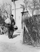 Chaufför Gustav Jarneving ute på dagens första filial-, bunt- och
expresskörning. Bunt till ett av brevbärareområdena lämnas in i en
tobaksaffär.