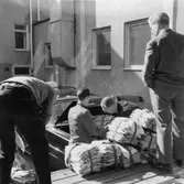 Exteriör från Solna 1. Ilastning av buntar i taxibil.