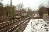 Järnvägsspår som går genom Grevedämmet. Till vänster, bakom växtlighet, skymtas Grevedämmets skola. Oktober 1998 - januari 1999.