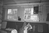 Byggnadsdetaljer: Kvarlämnade tygprover nedanför ett fönster i August Werners fabriker i Lindome. I taket ser man vattenrör. Hösten 1994.