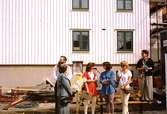 Folksamling vid Lyktplatsen i Kvarnbyn. Gatlyktan invigs på Kvarnbydagen 25/4 1993. Mannen till vänster är Lars Gahrn. Den vita byggnaden i bakgrunden är Korndal 2.