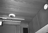 Mölndals stadshus, juni 1994. Del av vägg och tak klädda i ek-panel i ett sammanträdesrum. I taket sitter skenor samt en lampa. På väggen finns en ventil.