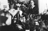 Nora Krantzs födelsedag, troligtvis 60 års-dagen, Stretered 1930-tal
. Nora (mormor till givaren) sitter vid ett blomsterbord.