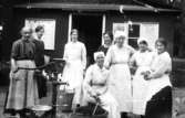 Kvinnorna är samlade vid vattenpumpen för gemensam tvättdag, år 1921.
Kvinnan som sitter heter Viktoria Westerberg (moster till givarens mamma).