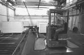 En man sitter i en truck.
Bilden ingår i serie från produktion och interiör på pappersindustrin Papyrus1980-tal.