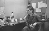 En man har kaffepaus på pappersfabriken, 1980-tal.
Bilden ingår i serie från produktion och interiör på pappersindustrin Papyrus.