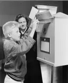 Ett första-dagsstämplat brev läggs ned i brevlådan vid den
tillfälli-ga kassaexpeditionen, i moderna postkontoret på 2 trappor.