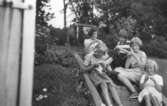 Fem flickor sitter i trappan och stickar, vid Gamlehagsvägen 7 i Torrekulla cirka 1956. Från vänster: sommargästerna Barbro Lundberg, Inger Svensson, Barbro Arnesten. Till höger sitter systrarna Eva (gift: Kempe) och Karin Pettersson (gift: Hansson).