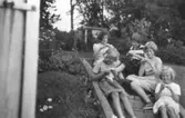 Fem flickor sitter i trappan och stickar, vid Gamlehagsvägen 7 i Torrekulla cirka 1956. Från vänster: sommargästerna Barbro Lundberg, Inger Svensson, Barbro Arnesten. Till höger sitter systrarna Eva (gift: Kempe) och Karin Pettersson (gift: Hansson).