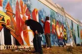 Graffiti längs Kvarnbygatan i Mölndal, år 2003. Två graffitikonstnärer som arbetar med sina konstverk.