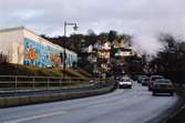 Graffiti längs Kvarnbygatan i Mölndal, år 2003. Till höger ses muren tillhörande Papyrusområdet och i bakgrunden skymtar Mölndals kvarnby.