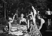 Barn och vuxna fikar på stranden vid Tulebosjön, cirka 1930. Karl Alberts står i bakgrunden till höger.