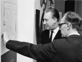 Intendent Gilbert Svenson (t.h.) guidar generaldirektör Nils Hörjel
på utställningen - här i receptionsrummet.