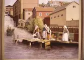 Några kvinnor tvättar kläder och mattor i Forsen i Kvarnbyn, Mölndal.
En tavla målad av den naivistiske mölndalskonstnären Knut Berg.