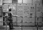 Man i arbete vid kontrollpanel på pappersbruket Papyrus i Mölndal, år 1990.