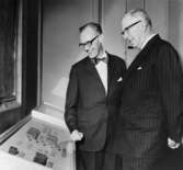 Jubileumshedersgäst var dåvarande kung Gustaf VI Adolf. Här
berättar museichefen Gilbert Svensson för kungen om tryckmaterialet
till skilling banco-frimärkena.