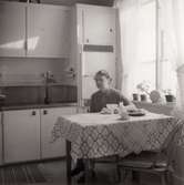 Inga-Lill Börjesson vid köksbordet på 1950-talet. Fotografi efter kylskåp installerats. Se även MMF2012:0048.