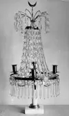 Gustaviansk lyster med slipade kristallprismor och marmorsockel med plats för fyra ljus. Gunnebo slott, 1930-tal.