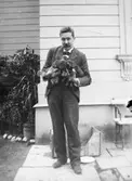 Friherre Carl Ambjörn Gustaf Sparre (1863-1917) med fyra hundvalpar i famnen. Gunnebo slott 1910-tal. Carl Sparre var gift med Fru Hilda Rakel Maria Sparre, född Deningshoff (1868-1948).