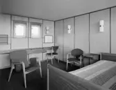 H55 Helsingborgsutställningen
Interiör, karmstolar, del av dubbelsäng i förgrunden.