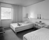 H55 Helsingborgsutställningen
Interiör, två sängar med nattygsbord emellan dem.