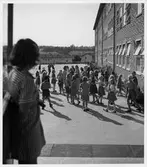 Riksby folkskola (Musikskolan, Västerortsdistr.)
Exteriör. Flicka i förgrunden, barn i bakgrunden.