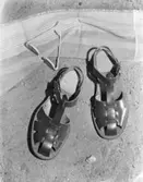 Sandaler, solglasögon och ett badlakan.