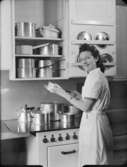 Kök
Kvinna framför kastrullskåp och gasspis
Interiör