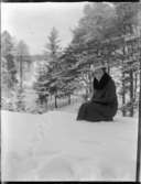 Vinterbild i skogen: Märta Svensson sittande.