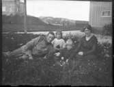 Familjen Furir Robert Svensson i gräset framför soldathemmet.