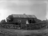 Kvinna utanför torp. Eventuellt Ebba Pettersson.