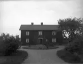 Man med hund framför hus