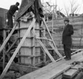 Lagerbyggnad 110 och 111 under uppbyggnad på Papyrus fabriksområde, 8/12-1945.
Två män är med på bilden. Mannen med glasögon är Agne Wieselqvist.