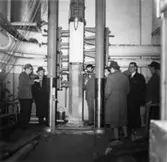 Provtryckning av pelare från byggnad nr 6.
Personer på bilden fr. v. William Tibell, okänd, okänd, okänd, okänd, Wiggo Odenius, okänd och okänd.