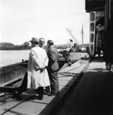 PM 3 Yankeecylindern transporteras till Papyrus fabriksområde via sjön.
Tre män är med på bilden.