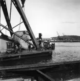 PM 3 Yankeecylindern transporteras till Papyrus fabriksområde via sjön.
Några män är med på bilden.