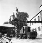 PM 3 ?? av maskindelar på Papyrus fabriksområde.
Några män är med på bilden.