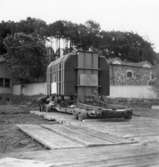 Transport av transformator 50 kW på Papyrus fabrik, 18/6-1955. Två okända män är med på bilden.