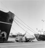 En man talar på bilradio framför skeppet Reykafoss