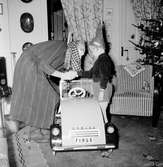 Jultomten kommer med julklappar till Tom Andersson på Odengatan 22 i Huskvarna, bland annat en bil som John Svanborg har gjort.