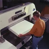 Man arbetar vid skärmaskin på Papyrus.