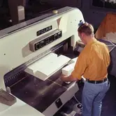 Man arbetar vid skärmaskin på Papyrus.