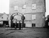 Omnibusstationen på Torsgatan i Huskvarna. Man kan tanka bensin och bentyl ur pumparna och enligt skylten på huset kan man också köpa tidningar och cigarrer.