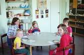 Barnverksamhet i Huskvarna. Barn och lärare har samlats kring borden för en måltid.